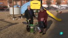 dos abuelos juegan con su nieta en el parque